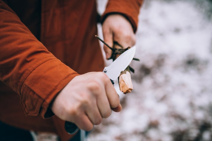 cutting a stick with a knife