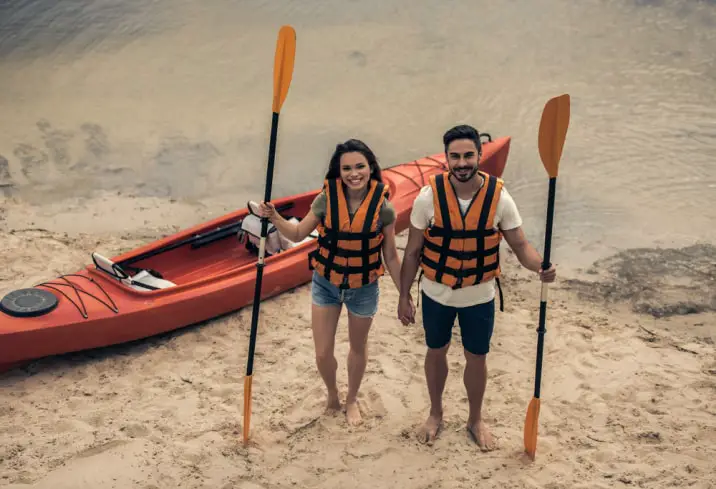 a couple with a kayak and oars